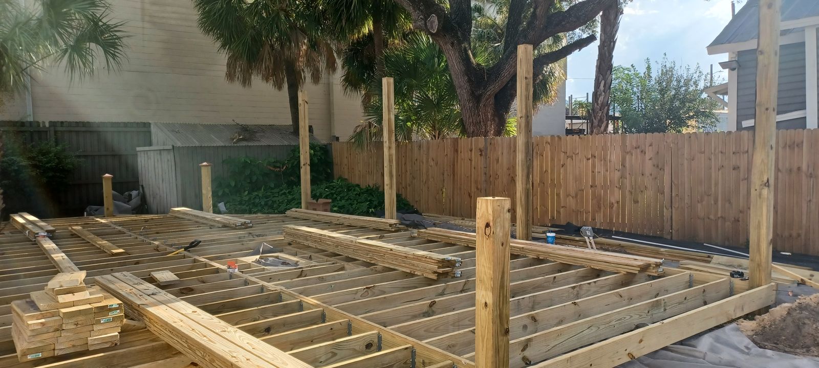 Custom backyard deck framing wrapping mature Florida palm trees in Brevard County