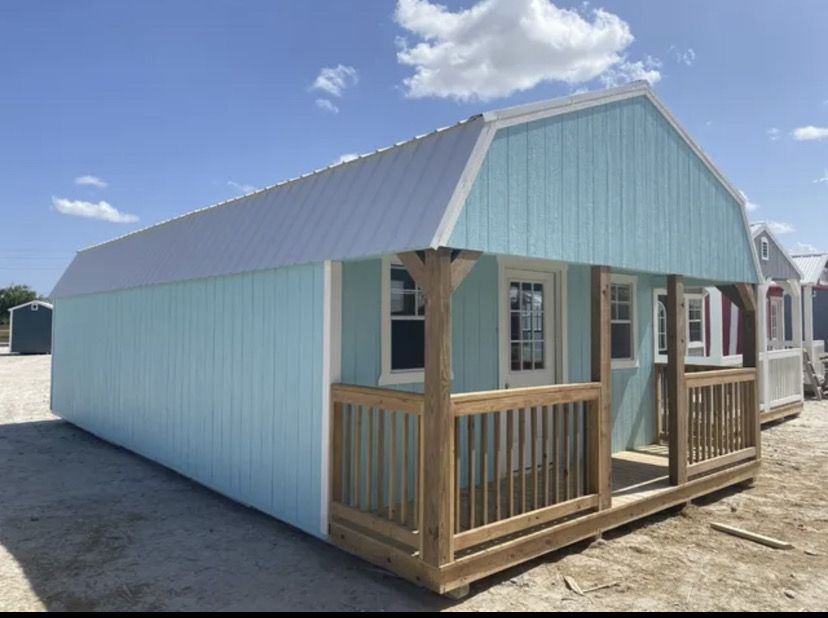 Custom teal tiny home exterior with covered front porch and gambrel roof built by Piper Outdoors